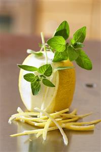 Lemon, partly peeled, lemon peel and oregano