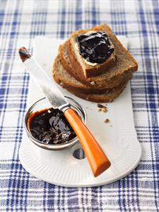 Plum and honey jam in small dish and on wholemeal bread