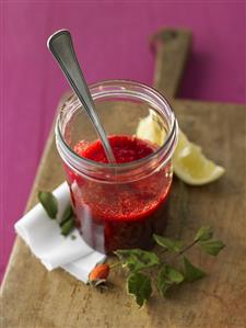 Wild berry sauce in jar with spoon