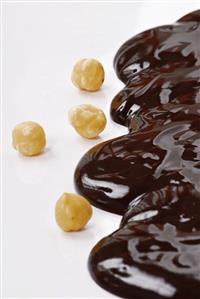 Chocolate sauce and shelled hazelnuts