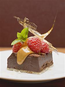 Piece of chocolate tart with raspberries and caramel