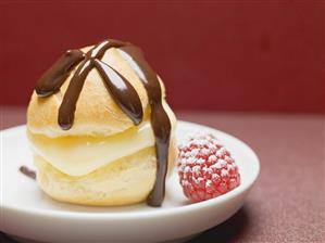 Profiterole with chocolate sauce, vanilla cream & raspberry