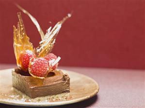 Small chocolate cake with raspberries and caramel fans