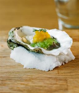 Oyster with cucumber and mango on a bed of salt