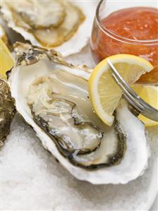 Fresh oysters with lemon and tomato sauce (close-up)