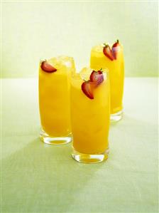 Three fruity rum drinks with carambola and strawberries