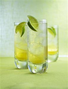 Three Drambuie Sodas with ice cubes and lime wedges