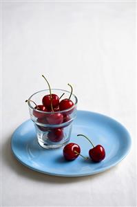 Cherries in glass and on plate