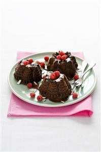 Small chocolate cakes with grated coconut and raspberries