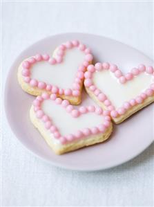 Heart-shaped iced biscuits with sugar pearls