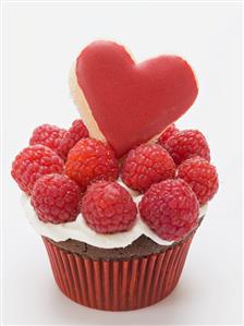 Chocolate cupcake with raspberries & heart-shaped biscuit. 