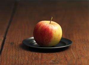 An Elstar apple on a pewter plate