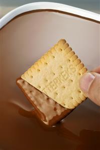 Dipping a biscuit in chocolate sauce