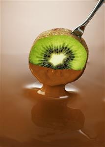 A slice of kiwi fruit in chocolate sauce