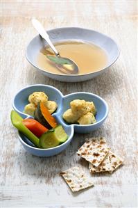 Chicken broth with matzah balls and vegetables