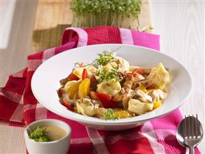 Tortellini with meat, red pepper and orange segments