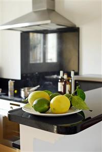 Lemons and limes on plate in kitchen