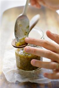 Putting kiwi fruit onto wooden spoon