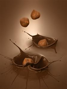 Hazelnuts falling into melted chocolate