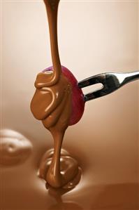 Pouring chocolate over a grape