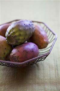 Several prickly pears in a wire basket