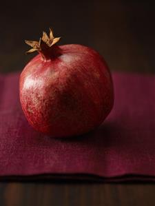 Pomegranate on burgundy red linen cloth