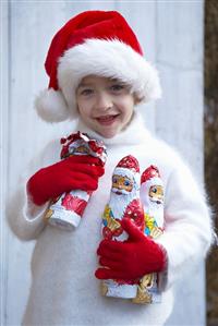 Boy in Father Christmas hat holding chocolate Father Christmases