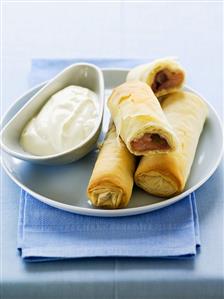 Filo pastry rolls with apple and rhubarb filling and cream