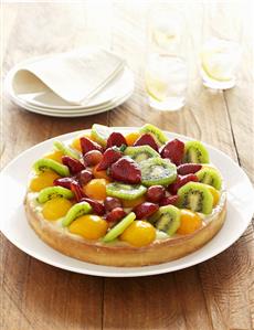 Fruit flan with apricots, kiwi fruit, strawberries & grapes