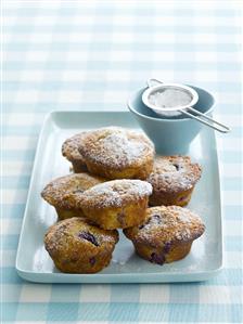 Plum muffins sprinkled with icing sugar