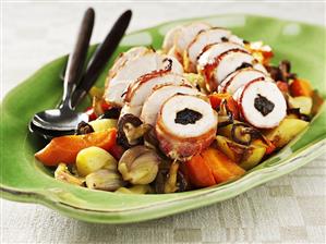 Chicken breast rolls with plum stuffing on vegetables