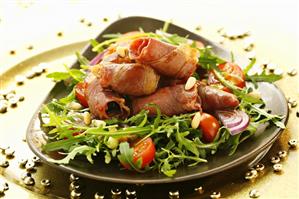 Bacon-wrapped prunes with rocket, tomatoes and pine nuts