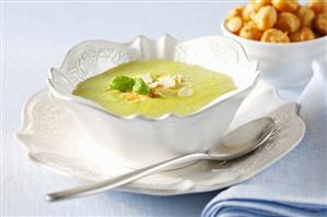 Cream of courgette soup with toasted almonds and basil