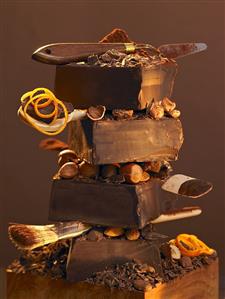 Stack of pieces of chocolate, nuts and baking utensils