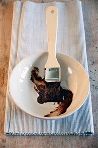 Brush with melted chocolate couverture in a dish