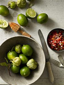 Still life with limes, green physalis and tomato salsa