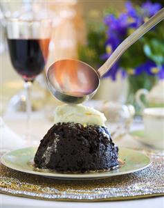 Flambéing Christmas pudding with orange cream