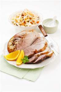 Roast pork with orange wedges, cabbage salad