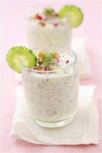 Cold yoghurt and cucumber soup with radishes in two glasses