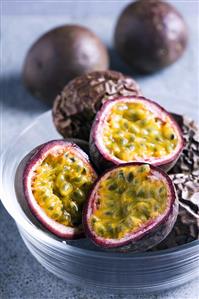 Purple passion fruits, whole and halved