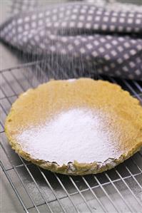 Dusting olive cake with icing sugar