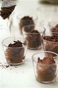 Sprinkling mousse au chocolat with chocolate shavings