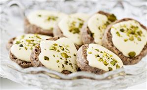 Nut biscuits with white chocolate icing and pistachios