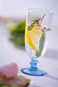 A glass of water with lemon and mint
