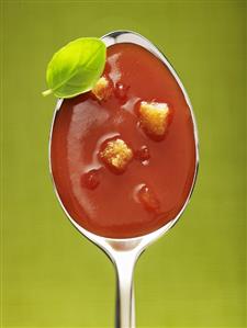 Tomato soup with croutons in spoon