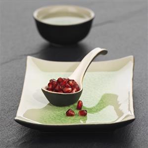 Pomegranate seeds in ceramic spoon