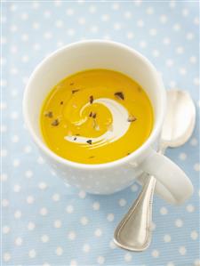 Pumpkin soup in cup with spoon