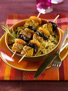 Pork and dried fruit kebabs on couscous