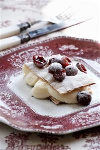 Vanilla cream between sheets of filo pastry with cherries