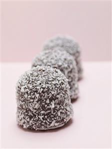 Three chocolate teacakes covered in grated coconut